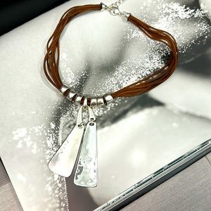 Leather necklace with silver like pendant.